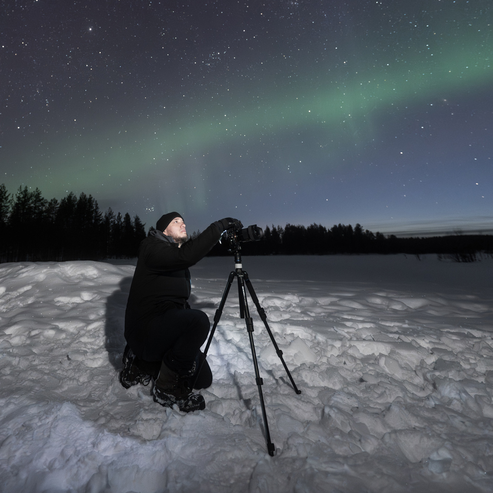 Ryan Olivera posing under the northern lights.